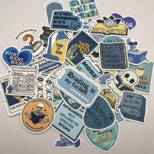 May include: A collection of blue and yellow book-themed stickers with various designs and text, including "Reading is my ticket", "Book Lover", "Read More Books", and "It's not hoarding if it's books".