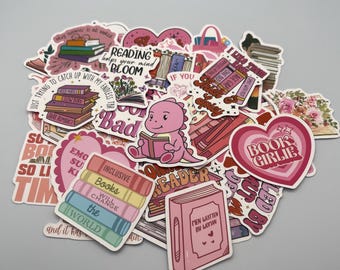May include: A collection of colorful stickers with a reading theme. The stickers feature books, hearts, and phrases like "Reading helps your mind bloom" and "Book Girlie." A pink dinosaur reading a book is also featured.