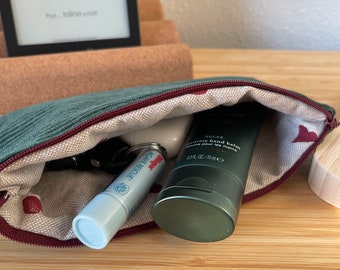 May include: A green zippered pouch with a red zipper pull, containing a small white tube of lip balm with the text "Active Rescue" and a green tube of hand balm with the text "Relax Recovery Hand Balm" and the text "2.3 fl oz / 70 ml e".