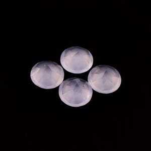 May include: Four pale lavender, faceted, round gemstones are arranged against a black background. The gems have a translucent quality, with multiple facets catching the light. The overall effect is one of delicate beauty and potential for jewelry making.