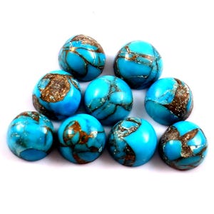 May include: A collection of nine polished turquoise-colored gemstones with a speckled, brown matrix. The stones are round and have a smooth, glossy finish. The gemstones are arranged on a white surface.