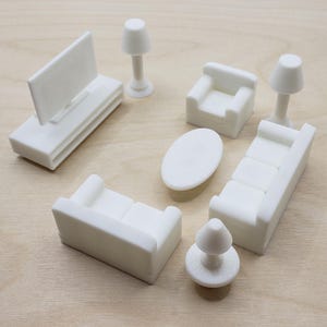 May include: A white miniature living room set with a TV, two couches, a coffee table, an armchair, and two lamps.