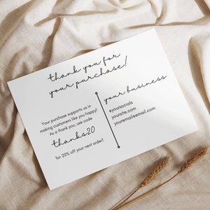 May include: A white thank you card with black text. The card says "Thank you for your purchase!" and "Your purchase supports us in making customers like you happy! As a thank you, use code thanks20 for 20% off your next order!" The card also includes contact information: @yoursocials, yoursite.com, and youremaileemail.com.