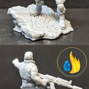 Puede incluir: Una figura en miniatura de pl&aacute;stico gris de un soldado sosteniendo un rifle, de pie sobre una base de pl&aacute;stico gris con una superficie texturizada. La figura est&aacute; en una postura de acci&oacute;n din&aacute;mica.