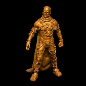 May include: A gold-colored figurine of a person wearing a cape and elaborate jewelry. The figurine is standing with its arms outstretched.