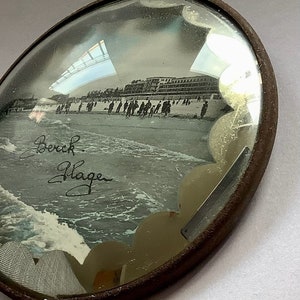 Cadre en verre bombé Berck Plage/ rehauts de bleu sur la carte postale à l’aquarelle (?)/ 11,5 cm de diamètre x 3 cm de profondeur