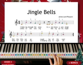 May include: A piano keyboard with colorful dot stickers on the keys, playing the sheet music for "Jingle Bells." The sheet music is displayed above the keys, with the title and composer's name visible. A Christmas tree and reindeer are in the background.