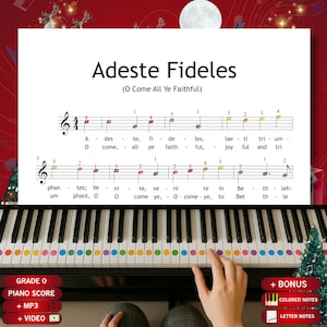 Könnte beinhalten: Eine Klaviatur mit farbcodierten Tasten und Notenblatt mit dem Titel "Adeste Fideles (O Come All Ye Faithful)". Das Notenblatt wird über der Tastatur angezeigt. Das Bild enthält den Text "GRADE 0 PIANO SCORE + MP3 + VIDEO + BONUS COLORED NOTES LETTER NOTES".