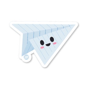 May include: A blue paper airplane with a smiling face and pink cheeks. The airplane is made of lined paper and has a white border.