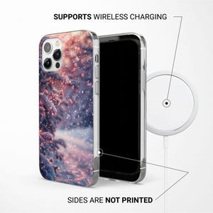 May include: A clear phone case with a wintery scene printed on the back. The scene features a snowy forest with pink and blue hues. The text "SUPPORTS WIRELESS CHARGING" is printed above the case. The text "SIDES ARE NOT PRINTED" is printed below the case.