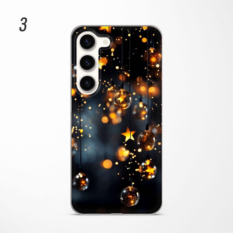 May include: A black phone case with a design of gold lights and stars. The phone case has a camera cutout with three lenses.