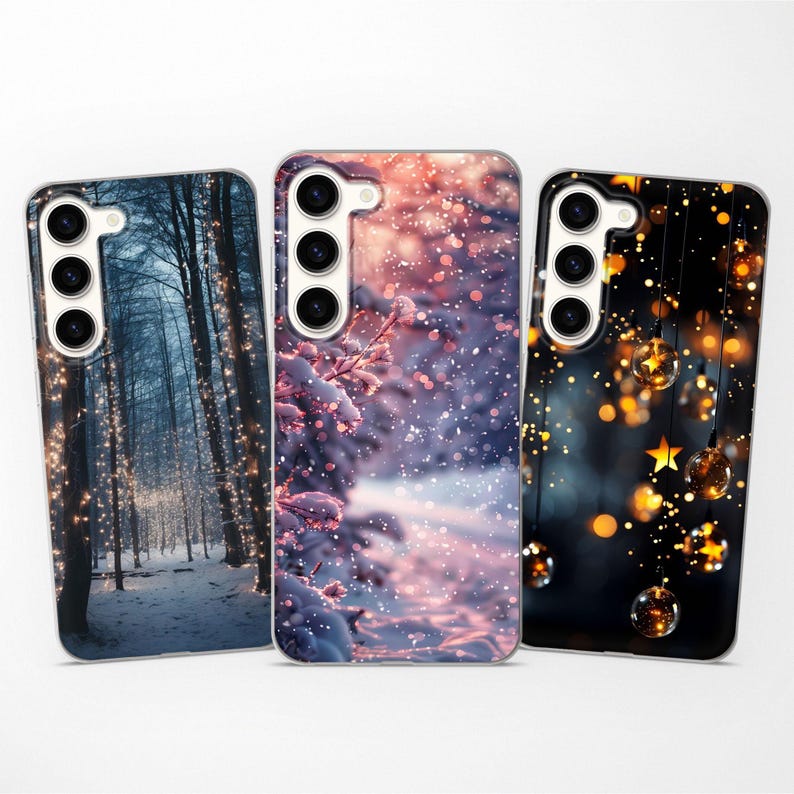 May include: Three phone cases with different winter-themed designs. The first case features a snowy forest with twinkling lights. The second case shows a close-up of a snowy branch with a pink and purple sky in the background. The third case has a dark blue background with a string of lights and stars.