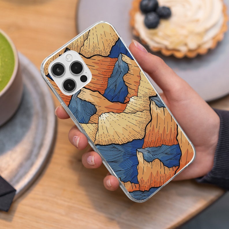 May include: A clear phone case with a colorful abstract design featuring orange, blue, and yellow hues. The design resembles a mountain range with wavy lines.