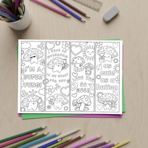 May include: A set of four black and white mushroom-themed bookmarks with cute illustrations and phrases like "I'm a super fungi" and "as cute as a button." The bookmarks are on a green and purple background, with pencils and an eraser in the background.