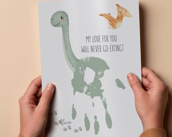 May include: A print featuring a dinosaur illustration and a handprint in green. The text "MY LOVE FOR YOU WILL NEVER GO EXTINCT" is displayed. The print also includes the name "Alice".
