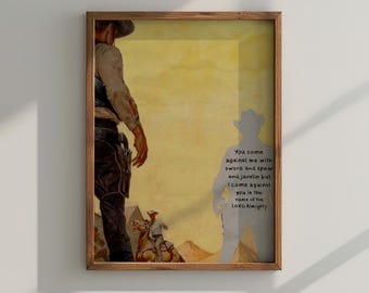 May include: Framed artwork featuring a cowboy in a hat, standing in a desert scene. The artwork has a vintage aesthetic with a yellow and brown color palette. Text on the right side of the image reads: "You come against me with sword and spear and javelin but I come against you in the name of the Lord Almighty."