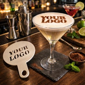 Può includere: Un cocktail con una schiuma in superficie, con il testo "YOUR LOGO" in marrone scuro. La bevanda è in un bicchiere a stelo, posto su un sottobicchiere quadrato nero. Una sagoma con lo stesso testo è vicina, insieme a strumenti da bar e guarnizioni.
