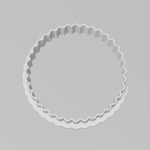 May include: White plastic cookie cutter with a scalloped edge. The cutter is shaped like a circle.