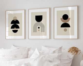 Op de afbeelding: Drie abstracte geometrische prints in beige frames aan een witte muur boven een wit bed met een wit dekbedovertrek en een sterrenpatroon.