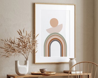Könnte beinhalten: Ein gerahmter Druck mit einem minimalistischen abstrakten Design, das einen Regenbogenbogen mit einem Kreis und einer Sichelform in gedeckten Tönen von Braun, Grün und Beige zeigt. Der Druck hängt an einer Wand über einem Holzregal mit Dekorationsartikeln.