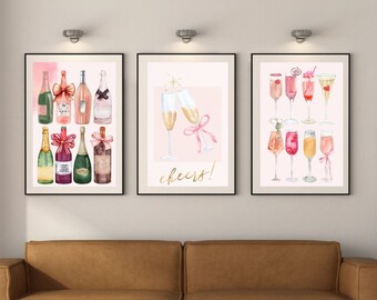 Puede incluir: Tres impresiones de acuarela enmarcadas con fondo rosa. La impresión de la izquierda presenta una colección de botellas de champán con cintas rosas. La impresión del centro presenta dos copas de champán con cintas rosas y el texto "¡salud!" La impresión de la derecha presenta una colección de copas de champán y cócteles.