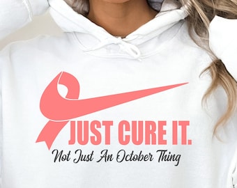 May include: White hoodie with a pink ribbon and the text "JUST CURE IT. Not Just An October Thing."