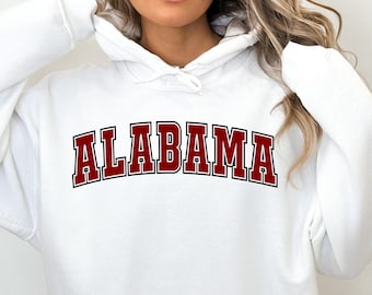 May include: White hooded sweatshirt with the word "ALABAMA" printed in maroon with a black outline.