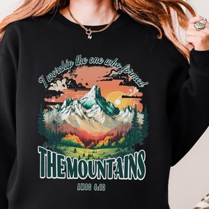 May include: Black sweatshirt with a colorful mountain landscape graphic and the text "I worship the one who formed THE MOUNTAINS" and the scripture reference "Psalm 148:13".