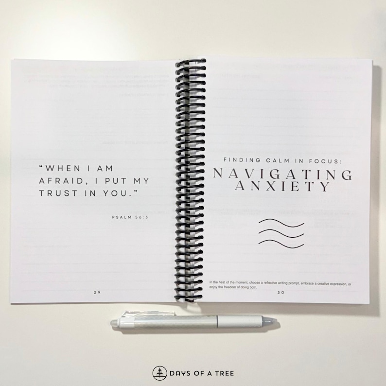 May include: An open spiral bound journal with a white cover and black text. The left page has a quote from Psalm 56:3, "When I am afraid, I put my trust in you." The right page has the title "Finding Calm in Focus: Navigating Anxiety" with a wavy line graphic.