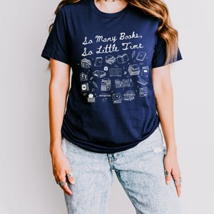 May include: A navy blue t-shirt with a white graphic of books and the text "So Many Books, So Little Time".
