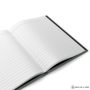Peut inclure: Un carnet &agrave; couverture vert fonc&eacute; ouvert sur une page blanche &agrave; lignes.
