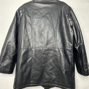 May include: Black leather jacket with a faux fur collar. The jacket has a double breasted closure and a long sleeve design.