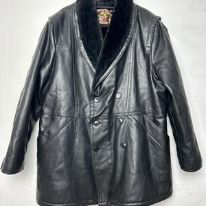 May include: A black leather coat with a faux fur collar. The coat has a double breasted closure and a long length.