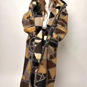 Natuurlijke leren shearling schapenvacht patchwork lange jas met capuchon en patroon van gevlekte schapenvacht, echt uniek, lange lengte.