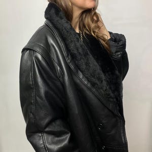 May include: A black leather jacket with a fur collar and a double-breasted closure.