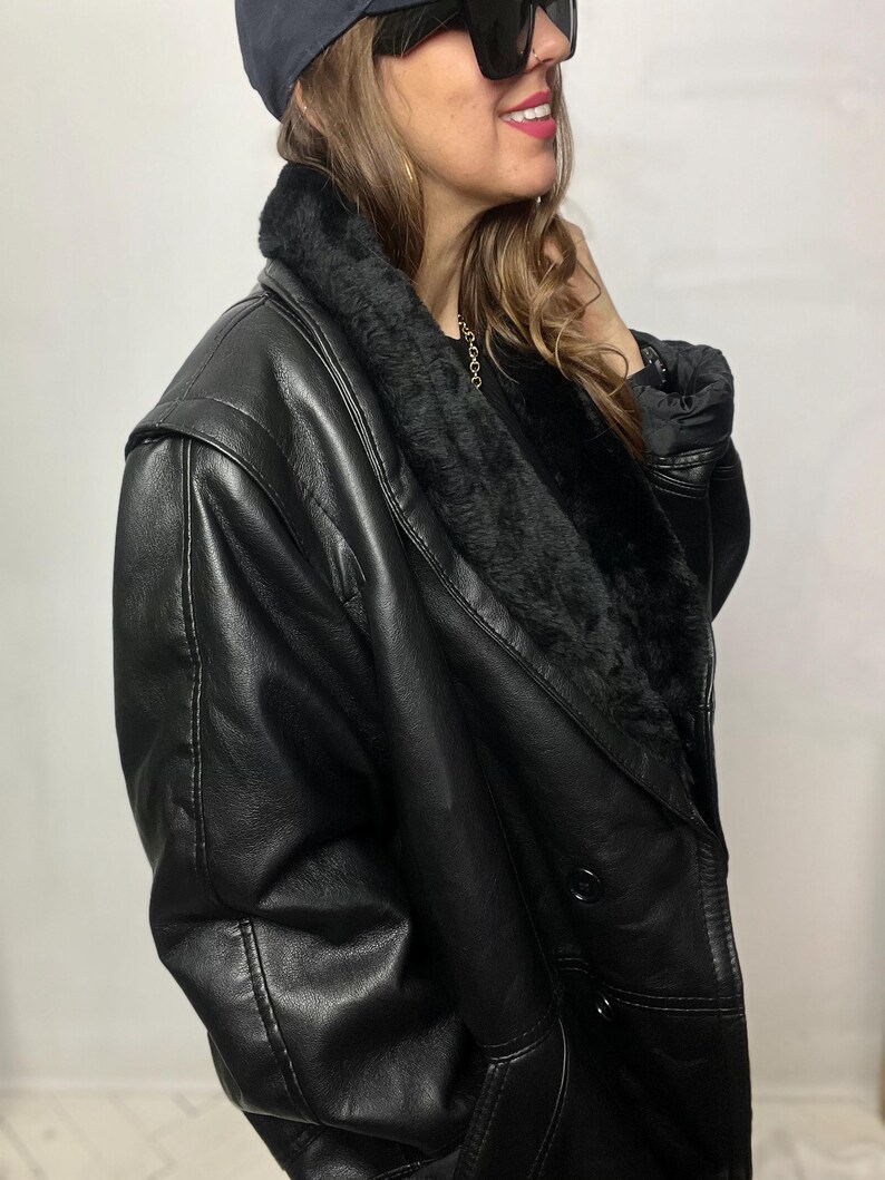 May include: A black leather jacket with a fur collar and a double-breasted closure.