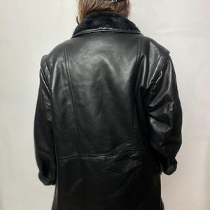 May include: A black leather jacket with a faux fur collar. The jacket has a zipper closure and two pockets.