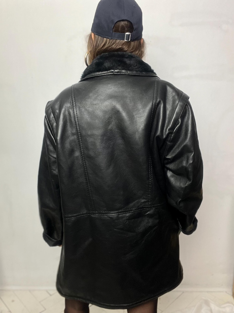 May include: A black leather jacket with a faux fur collar. The jacket has a zipper closure and two pockets.
