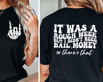 May include: Black t-shirt with a skeleton hand making a rock and roll sign on the front and the text "IT WAS A ROUGH WEEK BUT I DIDN'T NEED BAIL MONEY so there's that" on the back.