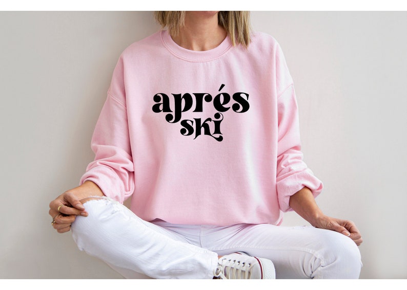 May include: A pink sweatshirt with the text "apr&egrave;s ski" in black retro-style lettering.