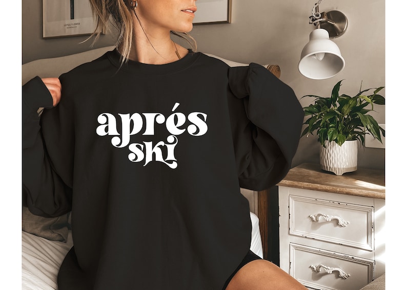 May include: A black sweatshirt with the text "apr&egrave;s ski" in white, retro-style lettering.