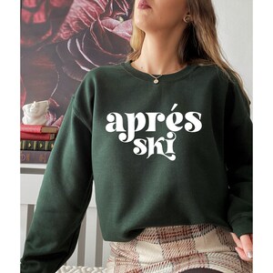 May include: A dark green sweatshirt with the text "apr&egrave;s ski" in white, stylized lettering.