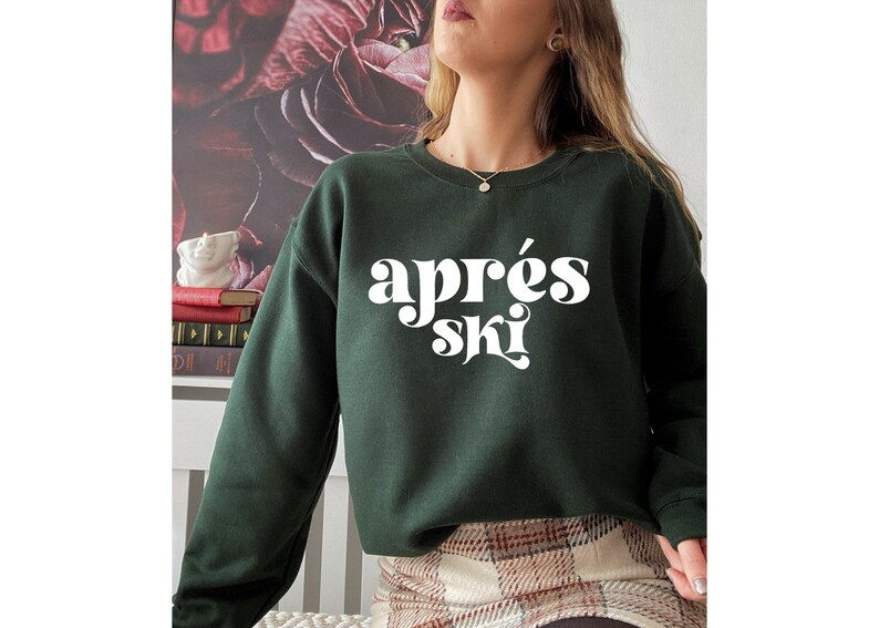May include: A dark green sweatshirt with the text "apr&egrave;s ski" in white, stylized lettering.