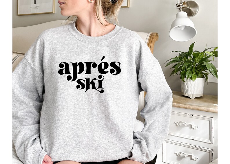 May include: A gray sweatshirt with the text "apr&egrave;s ski" in black, stylized lettering.