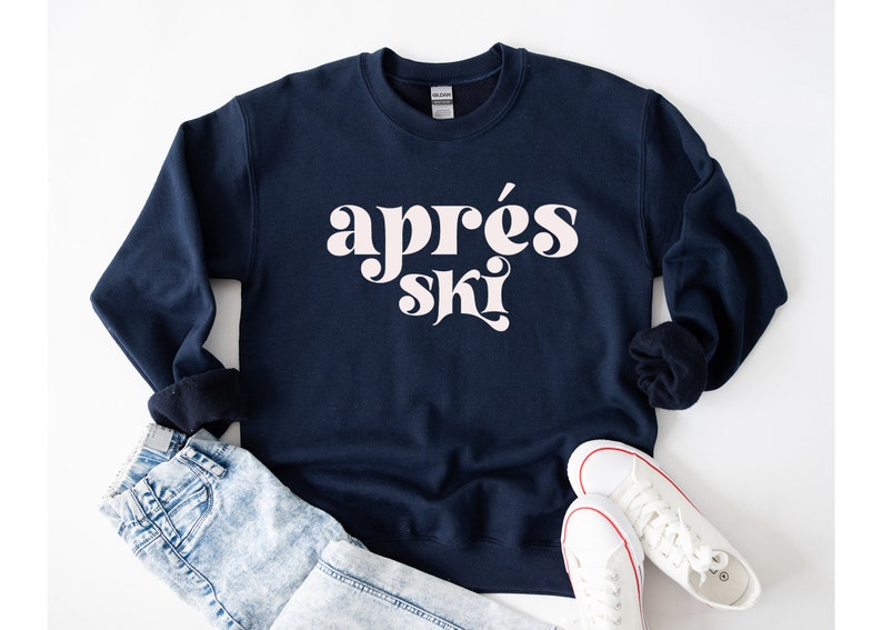 May include: A navy blue sweatshirt with the text "apr&egrave;s ski" in white retro-style lettering.
