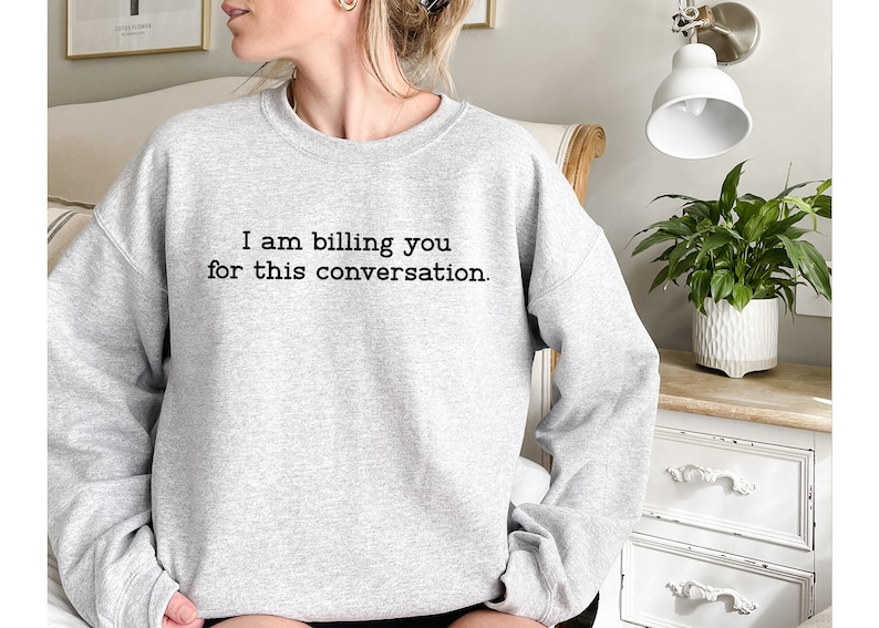 May include: A gray sweatshirt with the text "I am billing you for this conversation." printed on the front.