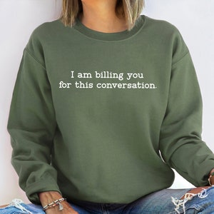 May include: A green sweatshirt with the text "I am billing you for this conversation." printed in white.