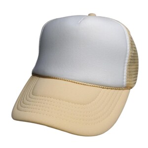 May include: A trucker hat with a white front panel, a beige brim, and a beige mesh back. The hat has a curved brim and a beige rope detail where the brim meets the front panel.