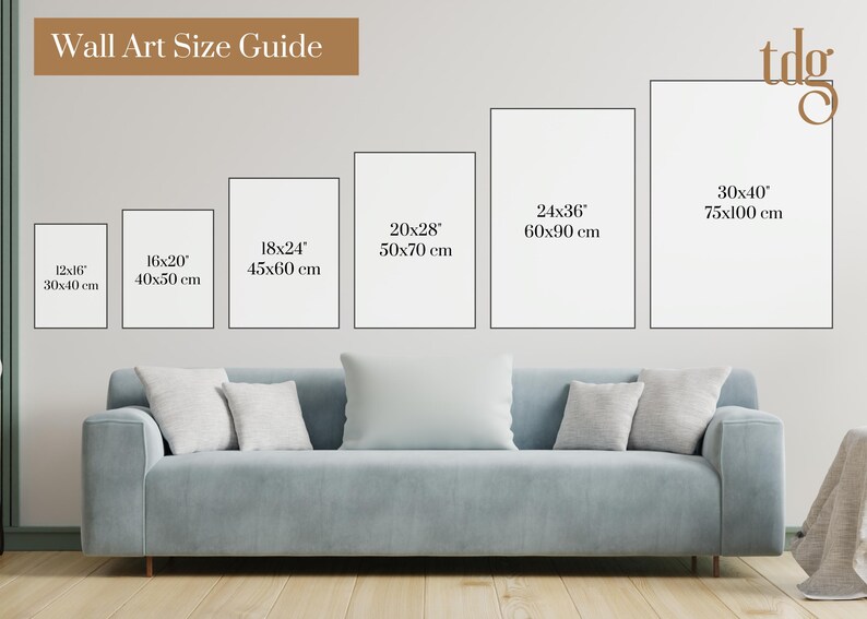 May include: A wall art size guide displays framed art in various sizes, including 12x16 inches (30x40 cm), 16x20 inches (40x50 cm), 18x24 inches (45x60 cm), 20x28 inches (50x70 cm), 24x36 inches (60x90 cm), and 30x40 inches (75x100 cm). The guide is above a blue sofa with pillows.