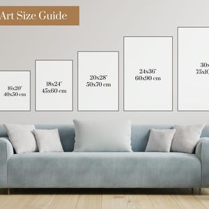 May include: Wall art size guide with six different sizes of white frames on a white wall. The sizes are 12x16 (30x40 cm), 16x20 (40x50 cm), 18x24 (45x60 cm), 20x28 (50x70 cm), 24x36 (60x90 cm), and 30x40 (75x100 cm). A light blue sofa is in the foreground.